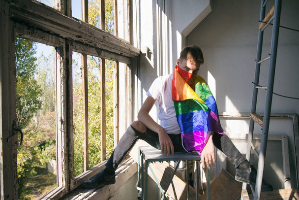 Борьба за их права. Равенство и свобода. Молодой привлекательный парень с гейским флагом. - Фото, изображение