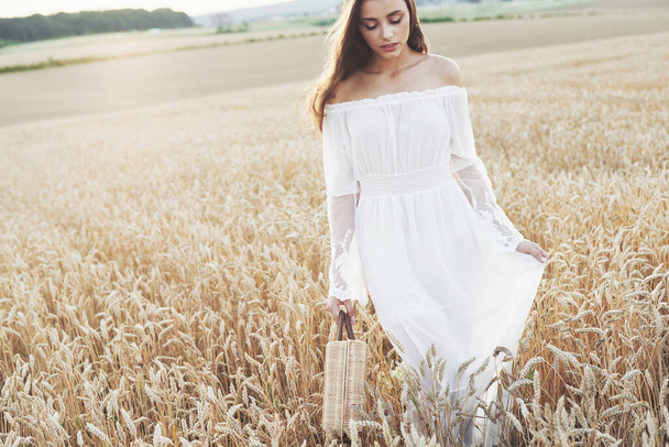 Beautiful girl in a field of wheat in a white dress, a perfect picture in the style lifestyle. - Foto, imagen
