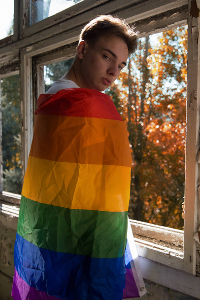 La lucha por sus derechos. Igualdad y libertad. Joven tipo atractivo con bandera gay. - Foto, imagen