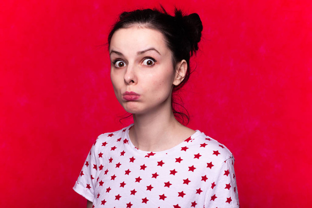 piękne emocjonalne dziewczyna w t-shirt na czerwonym tle - Zdjęcie, obraz