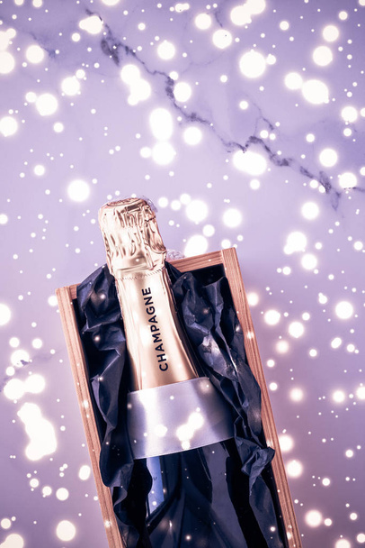 Champagnerflasche und Geschenkschachtel auf lila Urlaubsglitzern, neu ja - Foto, Bild