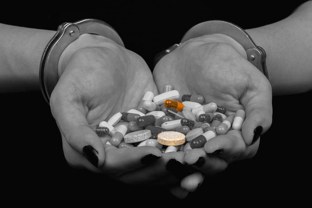 s rukama spoutanýma a léky pilulky na černém pozadí - Fotografie, Obrázek