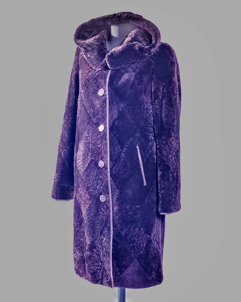 Casaco de peles longo feito de mouton, cortado em losango, com um capuz e bolsos ikos de cor violeta escura para o catálogo
 - Foto, Imagem