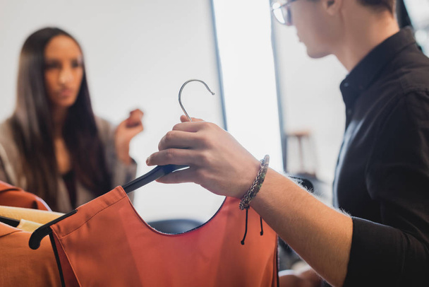 selective focus of stylist showing clothes to producer on backstage  - Foto, imagen