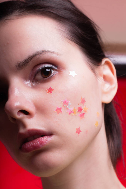 beautiful girl with sparkles on her face, close-up portrait - Фото, изображение