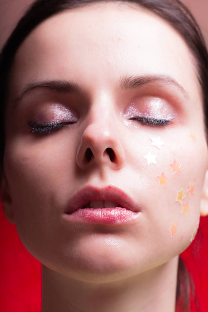 beautiful girl with sparkles on her face, close-up portrait - Photo, Image