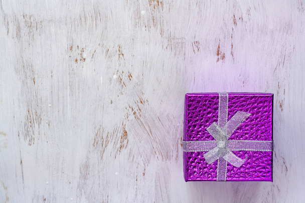 Плоский лежал. Подарочная фиолетовая коробка с бантом на белой поверхности, окрашенная кистью. Копирование текста
. - Фото, изображение