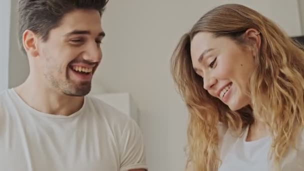 Cropped view of laughing young couple cooking together in the kitchen at home - Filmmaterial, Video