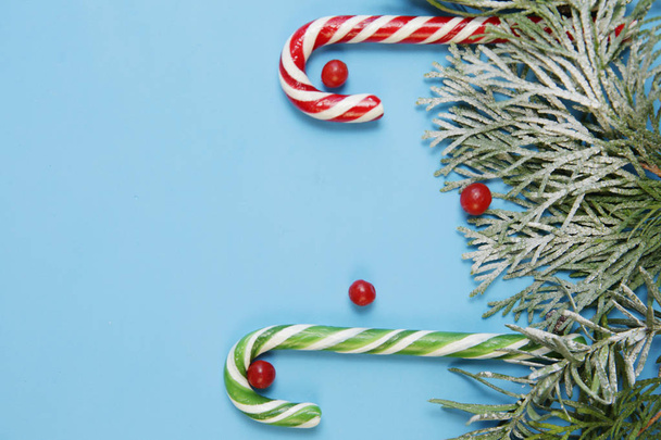 Christmas background or composition with fir branches and candy sugar cane. Christmas and New Year concept. Flat lay. Top view. Copy space. - Fotó, kép