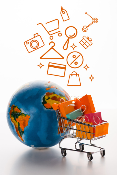 selektiver Fokus des Spielwarenkorbs mit globalnahen Einkaufstaschen und Abbildung auf Weiß, E-Commerce-Konzept - Foto, Bild