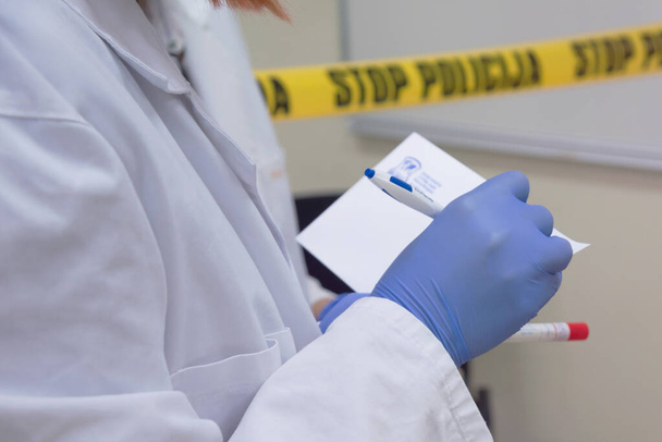 Судово-медичні фахівці, які беруть зразки ДНК з кров'яної плями з ліжком
 - Фото, зображення