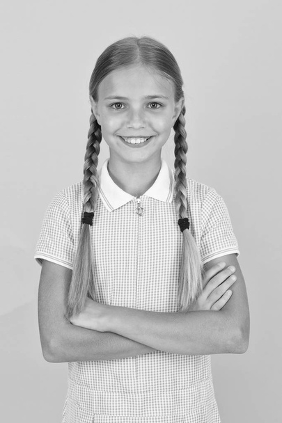 Emotional intelligence describes ability monitor your own emotions. Smiling girl. Adorable schoolgirl yellow background. Little girl. Happy childrens day. Tidy girl nice hairstyle. Positive emotions - Фото, изображение