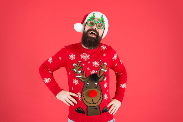 ho ho ho. bearded man santa hat red wall. christmas is here. man in xmas party glasses. happy new 2020 year. funny hipster knitted sweater. knitwear fashion. winter holiday celebration - Φωτογραφία, εικόνα