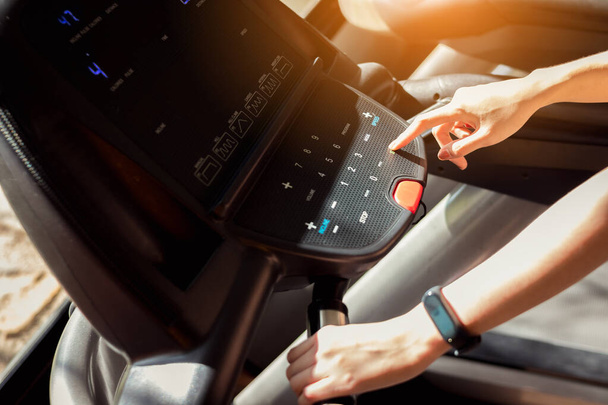 Fitness hand pressing treadmill button at gym. Healthy and lifestyle concept. - Foto, Imagem