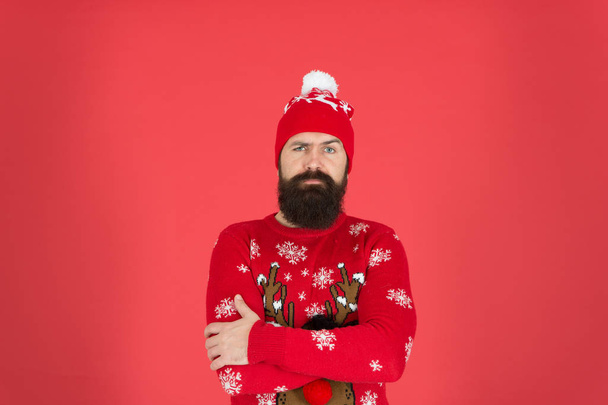 One out of control Christmas sale. wear warm clothes this season. its cold outside. winter holiday atmosphere. portrait sad santa man. bearded man in hat red wall. mature hipster in knitted sweater - Fotó, kép