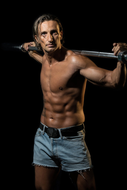 Bodybuilder Exercising Isolated On Black Background - 写真・画像