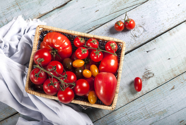 Tomatoes on rustic blue wood background top view copy space. - Foto, Imagem