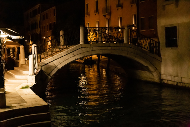 most nad kanálem v blízkosti starobylých budov v noci v Benátkách, Itálie  - Fotografie, Obrázek