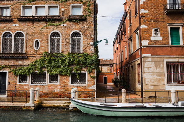 canal, barco a motor y edificios antiguos en Venecia, Italia
  - Foto, Imagen