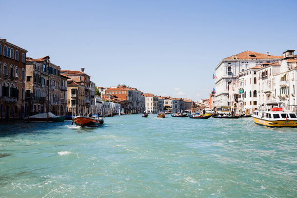 VENICE, ITALY - SEPTEMBER 24, 2019: vaporetto and motor boat floating on canal in Venice, Italy  - Fotó, kép