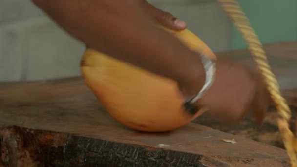 Nahaufnahme eines Mannes, der eine gelbe frische Kokosnuss schneidet. - Filmmaterial, Video