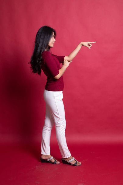 Corpo inteiro vista lateral de bela jovem asiático mulher apontando
. - Foto, Imagem