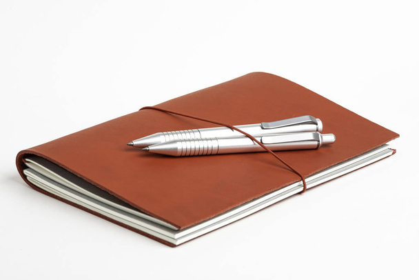 Cubierta de diario de cuero rojo con dos bolígrafos
 - Foto, imagen