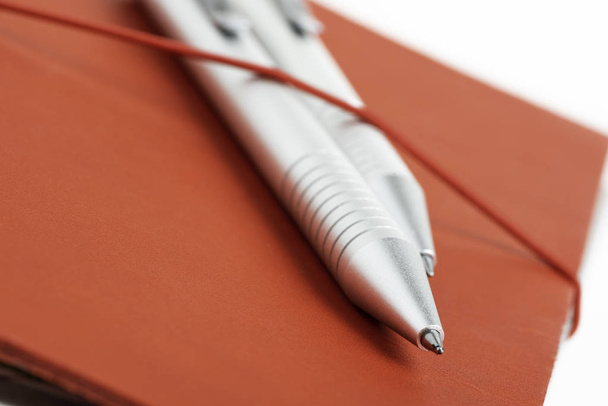 Cubierta de diario de cuero rojo con dos bolígrafos
 - Foto, imagen