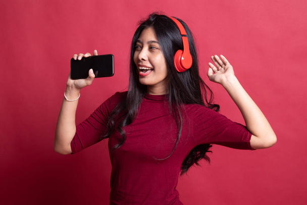 Pretty asian girl listening music with her headphones. - Zdjęcie, obraz