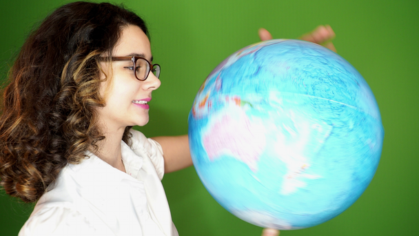 beautiful young girl with globe on green background - Metraje, vídeo