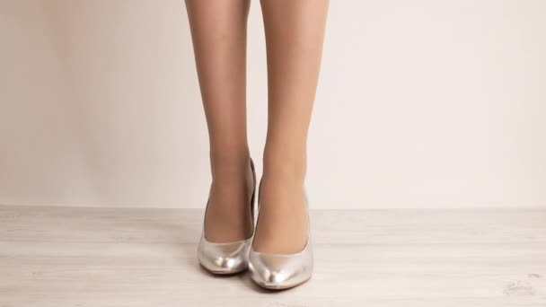 közeli felvétel nő elegáns magas sarkú cipő fehér háttér - Felvétel, videó