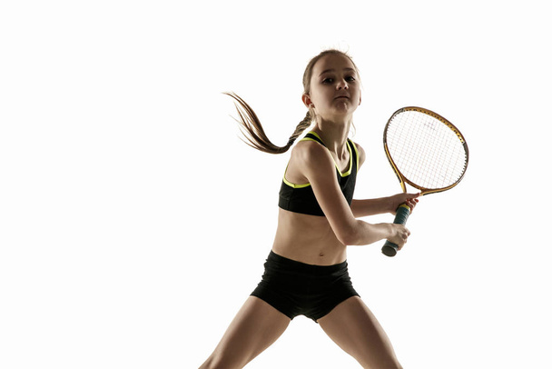 Piccola ragazza caucasica giocare a tennis isolato su sfondo bianco
 - Foto, immagini