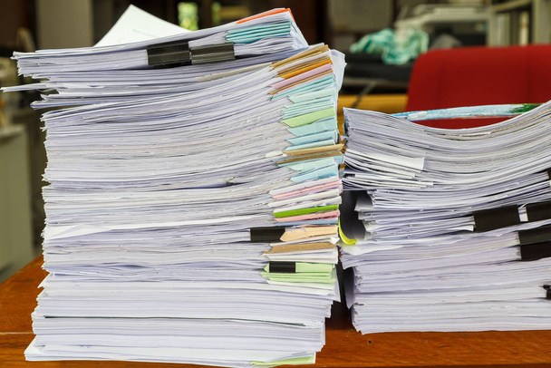 I documenti aziendali sono impilati sulla scrivania. Mucchio di documenti non finiti sulla scrivania dell'ufficio
 - Foto, immagini
