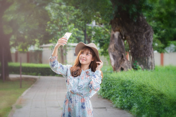 Jeune femme asiatique dans le style rétro prendre un selfie dans le parc
 - Photo, image
