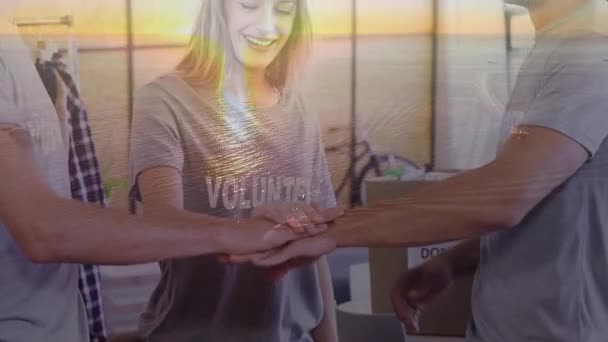 Animatie van twee mannelijke en een vrouwelijke collega 's die hun handen stapelen, glimlachen en succes vieren met zonsondergang op de achtergrond - Video