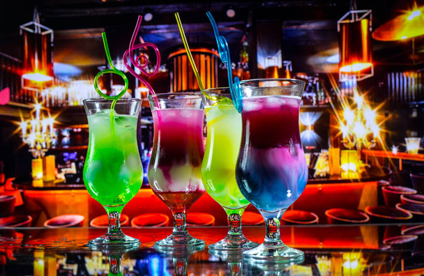 Склянка коктейлю розбризкується на темному тонованому димчастому фоні або барвистому коктейлі в склі. Вечірній клуб розваг. Змішане світло. Вибірковий фокус
 - Фото, зображення