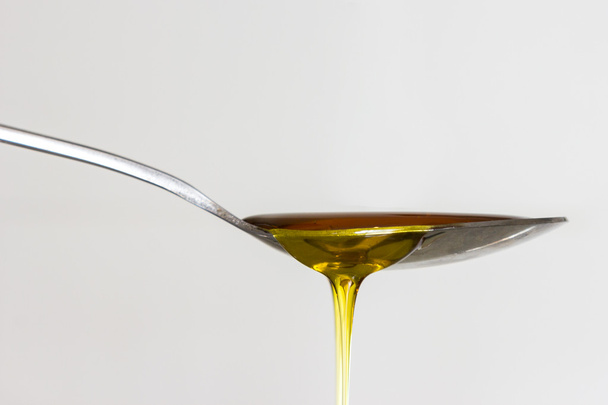 Honey flowing from spoon - Fotografie, Obrázek