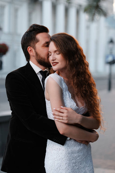Pretty newlyweds couple posing hugging on blurred city backgroud - Foto, afbeelding
