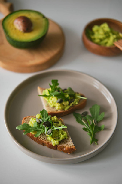 Food composition with deer wooden board with horns and avocado sandwiches - healthy meal - Foto, afbeelding