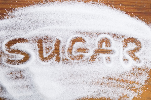 La parola zucchero scritto in una pila di zucchero bianco semolato
 - Foto, immagini