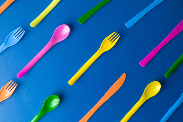 Multicolored cutlery on dark blue background abstract. - Valokuva, kuva