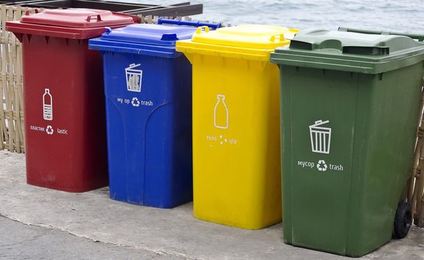 Quattro bidoni della spazzatura di colore nel parco accanto alla strada a piedi
. - Foto, immagini