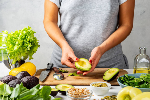 Woman peels avocado. cooking healthy food concept. - Photo, Image