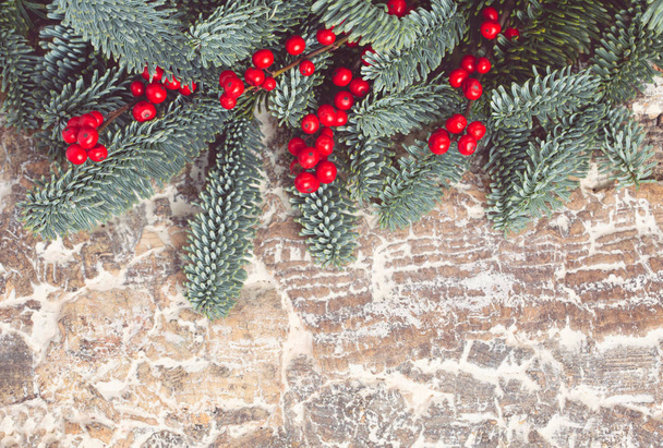 Composition de Noël. Cadre de branche d'épinette avec des baies rouges sur un fond en bois blanc
. - Photo, image
