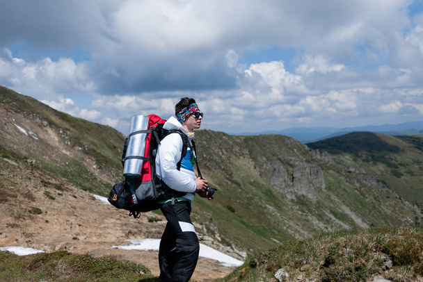 Tourist mit Foto-Aparat blickt in die Berge - Foto, Bild
