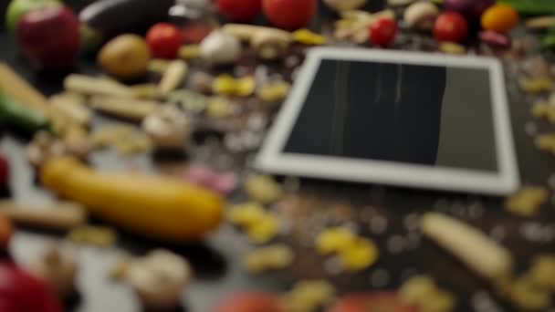 Świeże składniki makaronu w pobliżu białych tabletek PC - Materiał filmowy, wideo