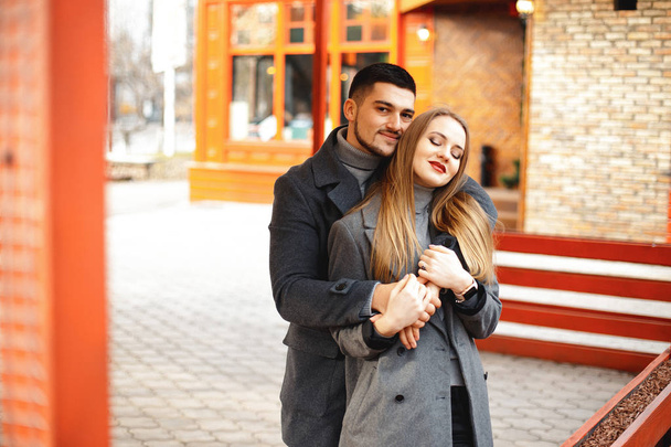 Loving couple in a coat walk along the street - Fotoğraf, Görsel