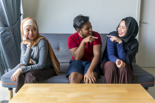 Concepto de poligamia marido con 2 esposas en el sofá
 - Foto, Imagen