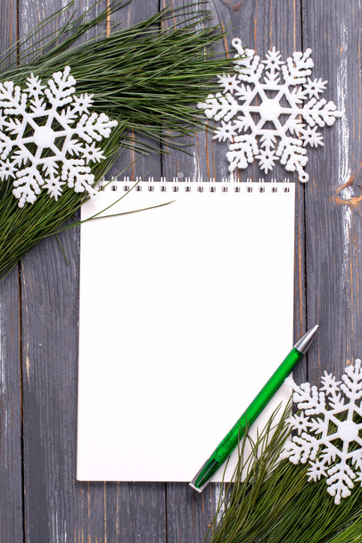 Christmas background with blank notebook, pine branches and Christmas toys on wooden table. Copy space. Flat lay - Foto, Bild