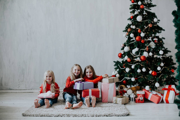 trzy dziewczyny blondynki siostry dziewczyny prezent nowy rok drzewo święto Boże Narodzenie - Zdjęcie, obraz